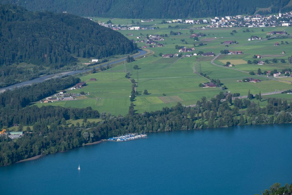 A scenic aerial view of lush green countryside with a lake and small village.