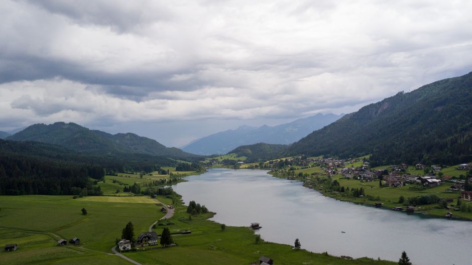 Cloudy day over Weißensee Lake, Kärnten, Austria, surrounded by mountains and lush greenery.